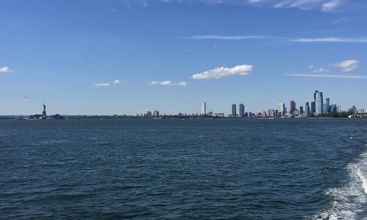 Frihetsgudinnen og Jersey City sett fra en ferge i New York-havna